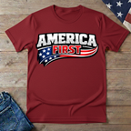 Red t-shirt with 'America First' graphic on a wooden surface